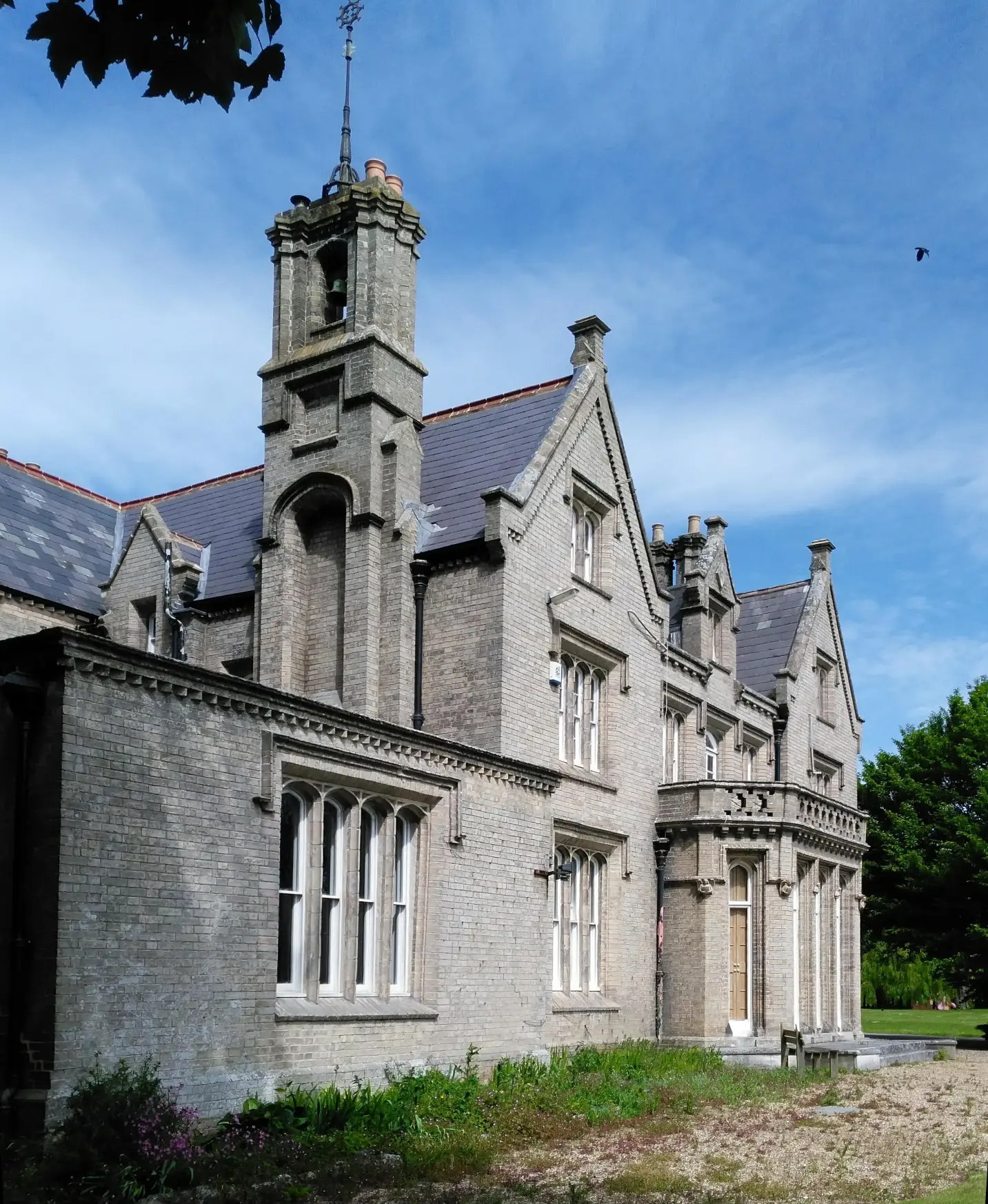 An image of a brick-built Tudor and Gothic revival manor house